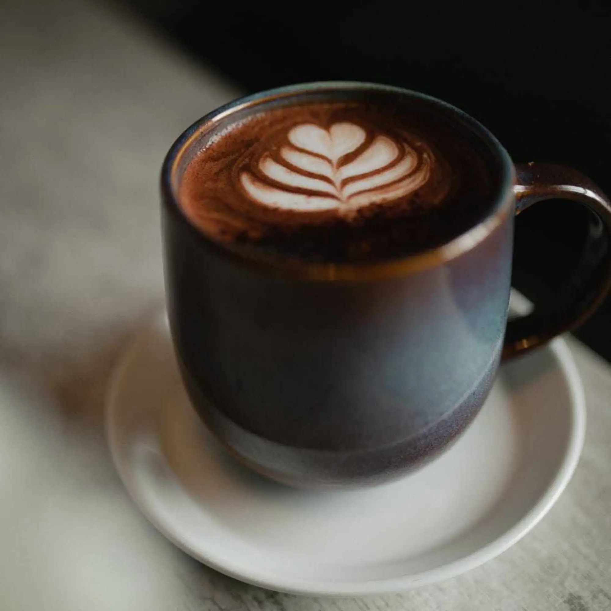 Taza de café con arte latte sobre una mesa